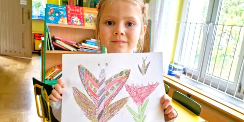Dziewczynka Małgosia trzyma rysunek motyla.